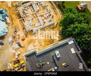 Primo piano aereo nuove costruzioni sito di sviluppo immobiliare. Cantiere urbano, vista aerea. Tetti e cantiere edile con wor Foto Stock