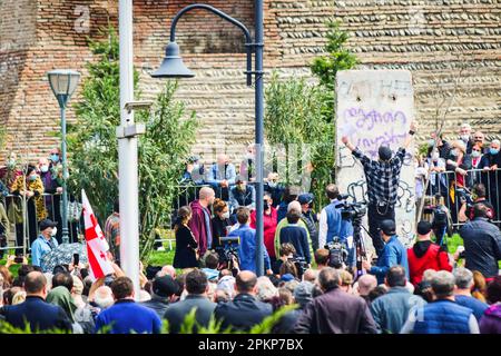 Tbilisi, Georgia - 9 aprile 2021: Giorgi Gachechiladze scrive 'Dio è amore' sul segmento delle mura di Berlino in piazza d'Europa. Foto Stock