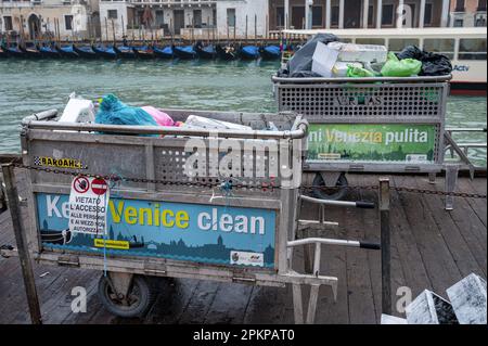 Venezia, Italia - 23 febbraio 2023: Bidoni dei rifiuti riempiti di rifiuti vicino al Canal Grande a Venezia pronti per essere raccolti. Foto Stock