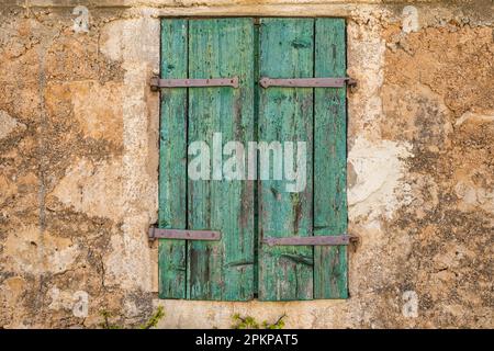 Finestra chiusa con vecchie persiane in legno Foto Stock