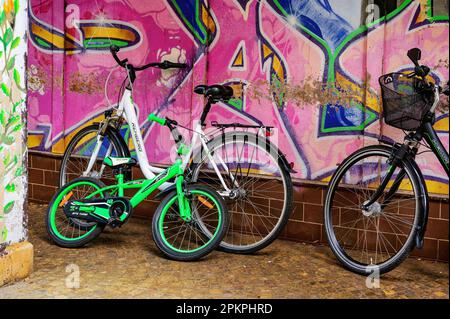 Salzwedel, Germania - 22 settembre 2021: Diverse biciclette parcheggiate contro un muro coperto da graffiti. Foto Stock