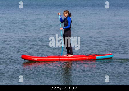 Sandbanks, Poole, Dorset UK. 9th aprile 2023. Tempo in Gran Bretagna: Caldo e soleggiato a Sandbanks a Poole, mentre gli appassionati di sport acquatici e gli appassionati si dirigono verso il mare per godersi le loro attività in acqua sotto il sole. Oggi, domenica di Pasqua, si prevede che sarà il giorno più caldo dell'anno fino ad oggi con le previsioni di pioggia di domani. Alzati il freno di rallentamento a pale. Credit: Carolyn Jenkins/Alamy Live News Foto Stock