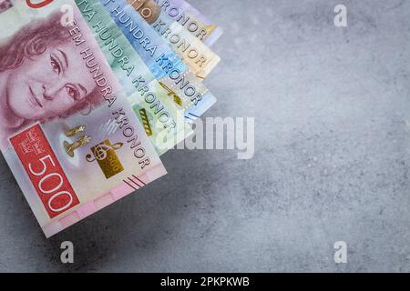 Denaro svedese su un banco grigio, spazio copia, business e concetto finanziario, primo piano Foto Stock