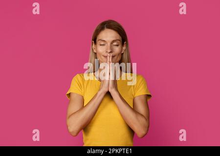 Allegro maturo europeo bionda femmina con gli occhi chiusi meditazione, godere la calma Foto Stock
