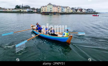 Le vogatrici su una tradizionale barca a remi in legno prendono parte a una gara mentre entrano nel villaggio di Killyleagh, nell'Irlanda del Nord. Foto Stock