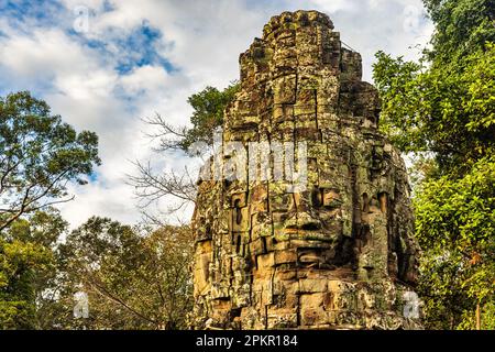 Faccia di pietra alla torre d'ingresso al tempio di Ta Prohm nel complesso di Angkor, Siem Reap, Cambogia Foto Stock