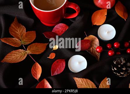 Autunno ancora vita con una tazza di caffè, candele e foglie di borgogna Foto Stock