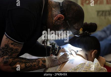 Lalitpur, Bagmati, Nepal. 9th Apr, 2023. Un artista tatuaggio inks un cliente durante la 10th International Nepal Tattoo Convention a Lalitpur, Nepal il 9 aprile 2023. Più di 200 artisti di tatuaggio da tutto il mondo si sono riuniti per mostrare le loro abilità nel convegno. (Credit Image: © Sunil Sharma/ZUMA Press Wire) SOLO PER USO EDITORIALE! Non per USO commerciale! Credit: ZUMA Press, Inc./Alamy Live News Foto Stock