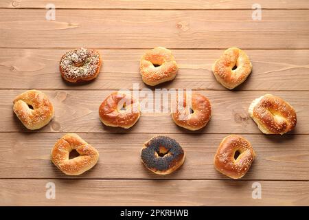 Gustosi bagel con semi di sesamo e papavero su sfondo di legno Foto Stock