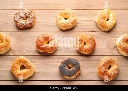 Gustosi bagel con semi di sesamo e papavero su sfondo di legno Foto Stock