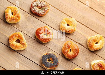 Gustosi bagel con semi di sesamo e papavero su sfondo di legno Foto Stock