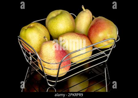 Diverse deliziose pere gustose in un cesto di metallo, primo piano, su sfondo nero. Foto Stock