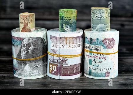 Rotoli di denaro egiziano banconote da 100 e 50 EGP LE cento dinari egiziani e cinquanta sterline e kuwait KWD uno, mezzo e quarto di valuta n Foto Stock