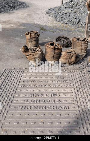Un cantiere di carbone del 1900 e un ponte pesante con sacchi di carbone all'esterno pronti per la vendita. Foto Stock
