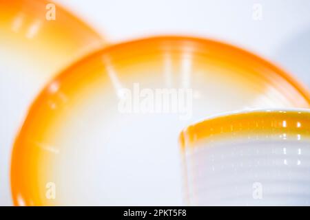 Tazza in ceramica bianca arancione e piatti primo piano Foto Stock