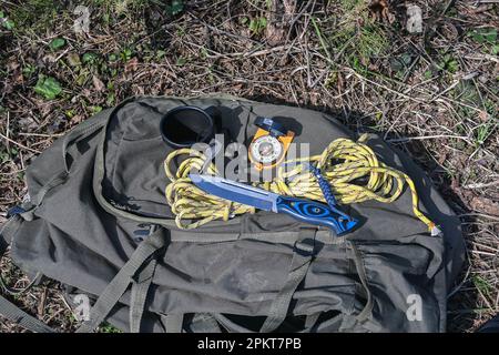 Attrezzatura Bushcraft. Coltello e corda illuminati dal sole. Foto Stock