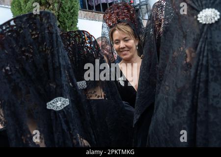 Setenil de las Bodegas, Spagna. 08th Apr, 2023. Donne spagnole che indossano il tradizionale merletto liturgico mantilla e pettini alti di peineta, si preparano per una processione durante la settimana Santa, conosciuta come Semana Santa, 8 aprile 2023 a Setenil de las Bodegas, Spagna. I residenti del piccolo villaggio di Setenil hanno vissuto in case grotta fin dal neolitico. Credit: Richard Ellis/Richard Ellis/Alamy Live News Foto Stock