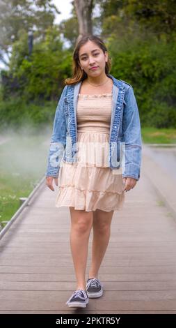 Asian Teen Walking on Misty Walkway | De Young Museum Gardens | Female | giacca in denim con abito corto Foto Stock