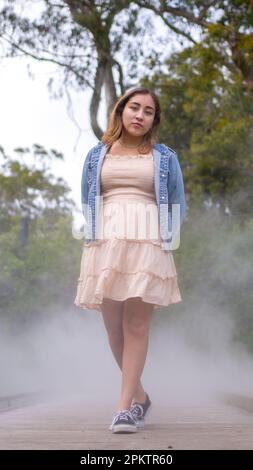 Asian Teen Walking on Misty Walkway | De Young Museum Gardens | Female | giacca in denim con abito corto Foto Stock