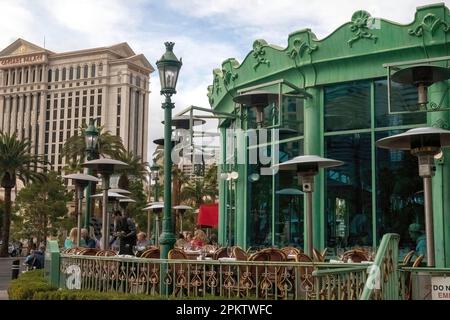 Posti a sedere all'aperto del Mon Ami Gabi, un ristorante francese nel Paris Hotel sul Las Vegas Boulevard con Caesars Palace in lontananza; a Las Vegas, Nevada. Foto Stock