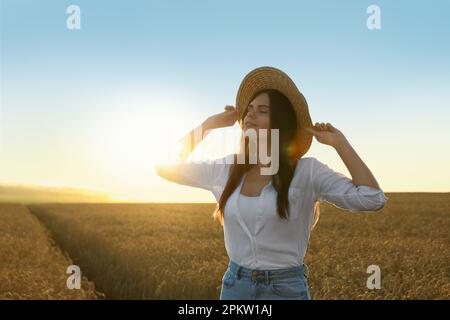 Bella giovane donna in campo di grano maturo il giorno di sole, spazio per il testo Foto Stock