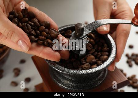 Donna che usa il macinacaffè manuale a tavola, primo piano Foto Stock