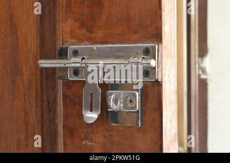 Vista ravvicinata della porta in legno con serratura a chiavistello scorrevole. Foto Stock