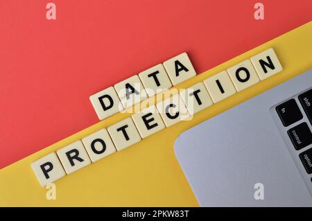 Lettere quadrate con PROTEZIONE dei DATI di testo su sfondo giallo e rosso. Foto Stock