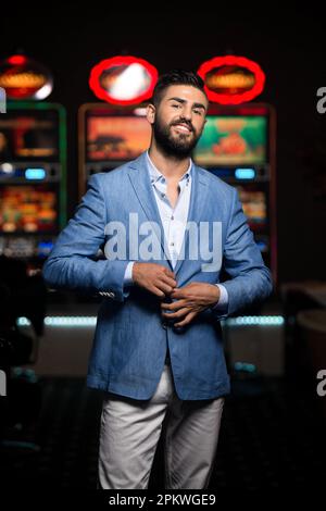 Ritratto di un giovane uomo arabo bello e ben vestito che gioca al Casinò e celebra Foto Stock