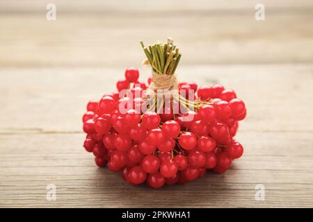 Bacche rosse di viburnum su fondo di legno grigio. Vista dall'alto Foto Stock