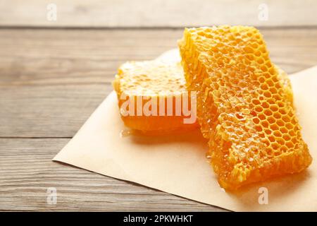 Dolce nido d'ape su sfondo di legno grigio, prodotti a base di miele da ingredienti naturali biologici concetto. Vista dall'alto. Foto Stock