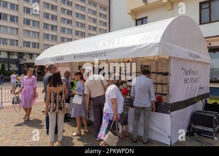 Grodno, Bielorussia - 30 giugno 2022: Scaffali con vestiti confezionati con le citazioni del presidente lukashenko stampato su di essi. I vestiti e i cappelli del ricordo sono così Foto Stock