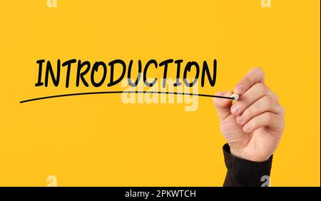 Presentazione introduttiva. La mano maschile disegna una linea sotto l'introduzione scritta a mano su sfondo giallo. Foto Stock