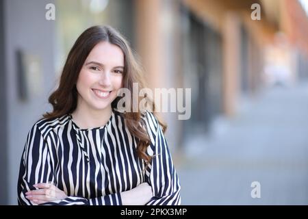 Vista frontale ritratto di una donna elegante in posa per strada Foto Stock