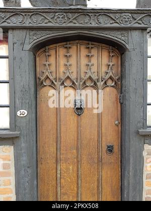 Tradizionale porta in legno intagliato con battente della porta della testa di un leone. Foto Stock