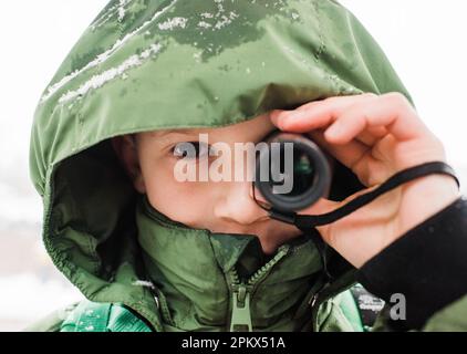 primo piano del ragazzo che guarda attraverso un telescopio Foto Stock