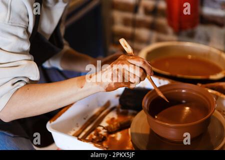 potter con uno studente sulla ruota del vasaio fa piatti di argilla Foto Stock