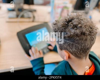 vista a spalla di gara mista primo livellatore su tablet Foto Stock