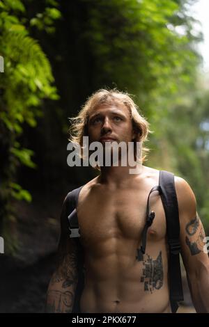 Un giovane viaggia attraverso le giungle tropicali di Bali. Foto Stock