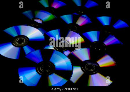 CD e DVD isolati su sfondo nero con riflessi colorati Foto Stock