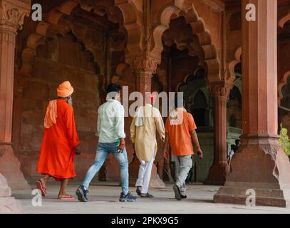 Turisti indiani che camminano attraverso i colonnati di pietra di sabbia rossa di Diwan-i-AMM nel Forte Rosso, Delhi, India Foto Stock