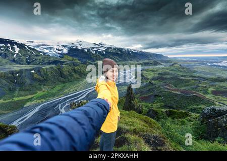 Giovane ragazza asiatica che tiene le mani con la coppia guardando la vista sulla cima della montagna a Valahnukur punto di vista, Thorsmork, Islanda Foto Stock