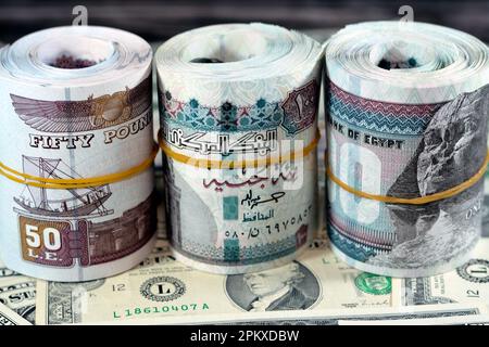 Rotoli di denaro egiziano banconote da 100 e 50 EGP LE cento egiziano e cinquanta sterline sulla valuta americana USA dollari vecchie banconote d'epoca, Egy Foto Stock