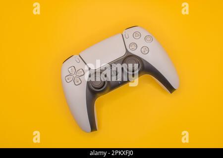 Parigi, Francia - 04 07 2023 : gamepad PlayStation 5 su sfondo giallo Foto Stock