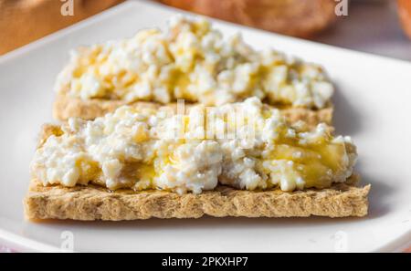 Colazione a base di pane dietetico con formaggio casolare e miele Foto Stock