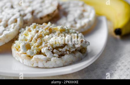 Panino con formaggio di ricotta, miele e banana su un pane dietetico. Mangiare sano Foto Stock