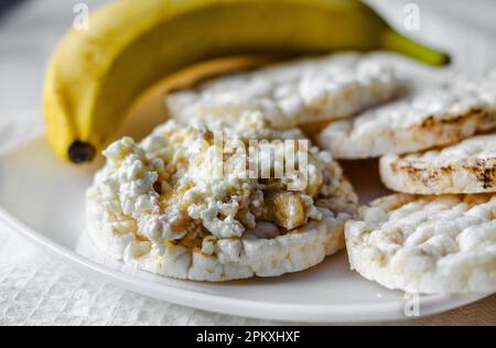 Panino con formaggio di ricotta, miele e banana su un pane dietetico. Mangiare sano Foto Stock
