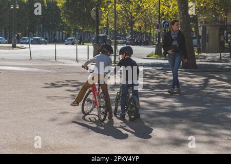 I ragazzi che indossano i caschi si divertono in bicicletta insieme in una giornata di sole a Parigi Foto Stock