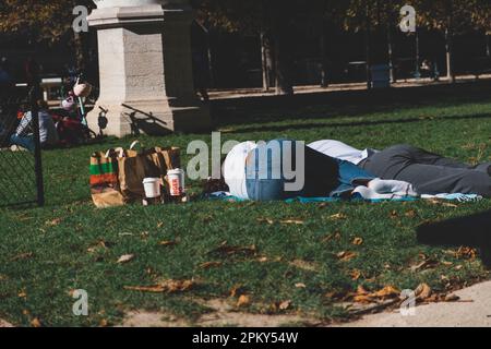 Couple Falls dorme sull'erba dopo aver gustato un pasto Burger King Foto Stock