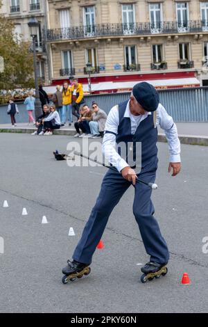 Spettacolo senza tempo: Un uomo di 60 anni con un abbigliamento anni '1940 esegue impressionanti trucchi Roller Blade su un ponte parigino, catturando gli spettatori Foto Stock